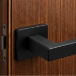 Poignée de porte Kvadrato II noire sur porte en bois, mise en situation illustrative